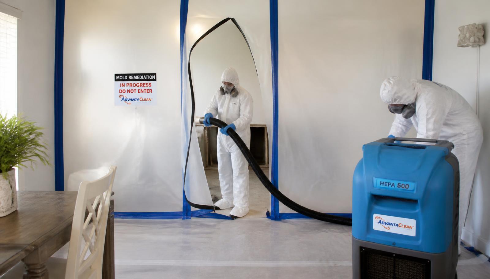 Certified technicians in protective suits performing contained mold remediation in an Orlando home