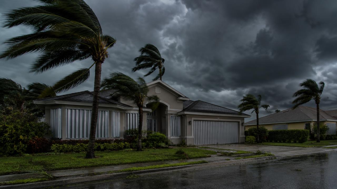 Orlando home with storm shutters under dark hurricane clouds